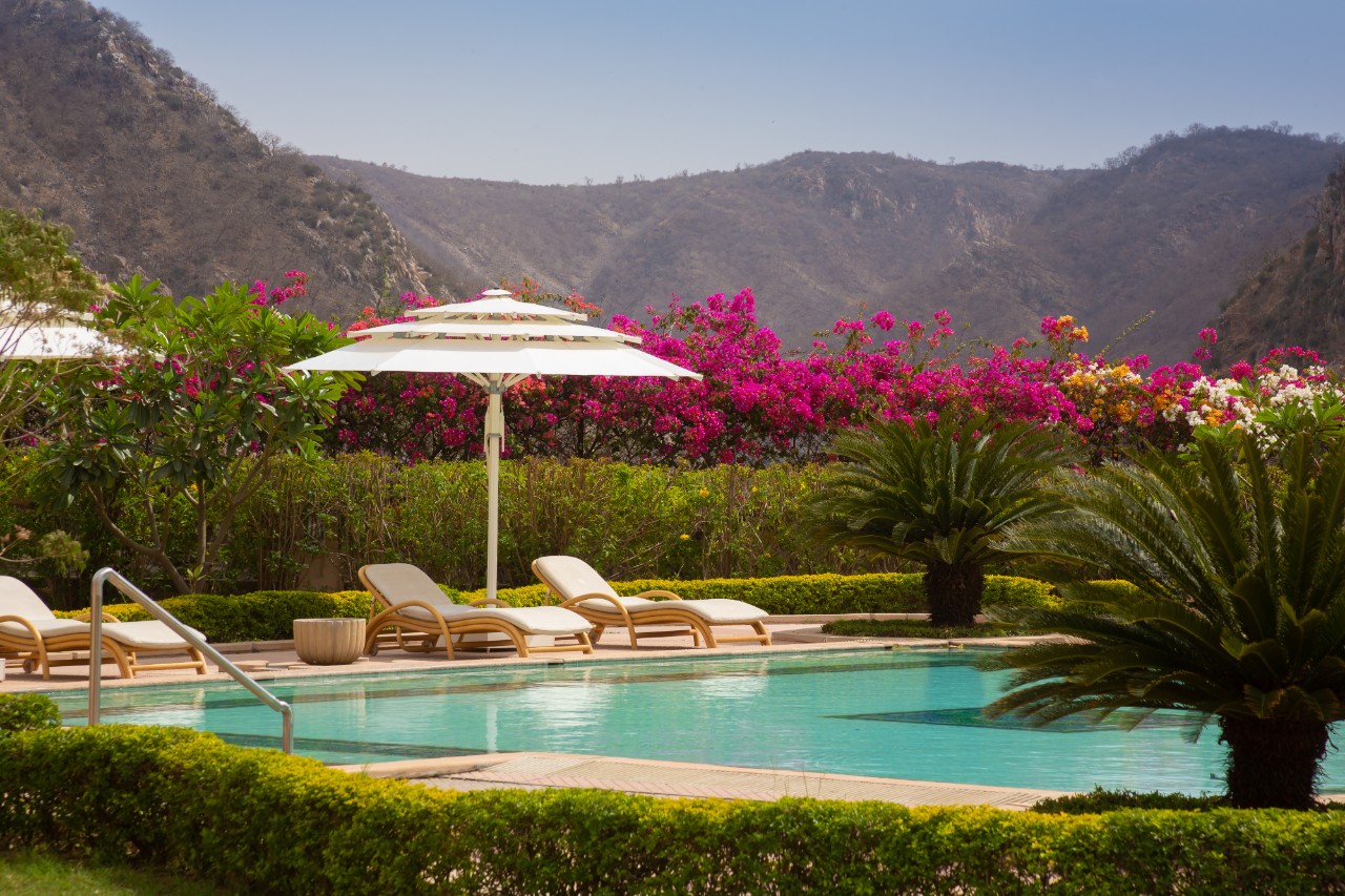Outdoor swimming pool with Aravalli hill view at Ramgarh Lodge, IHCL SeleQtions, a 5-star hotel in Jamwa Ramgarh.